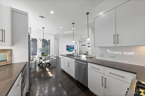 a kitchen with lots of counter top space a sink appliances and cabinets