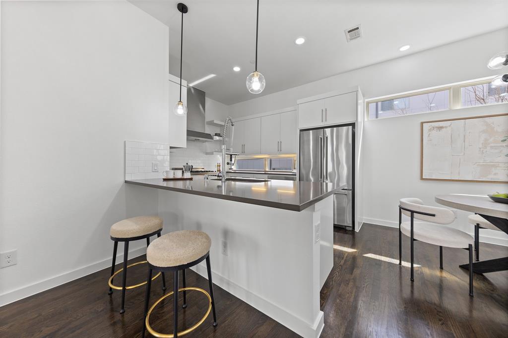 1915 Summit Avenue, Unit 2 Dallas, TX 75206 - Photo 7 of 39 a kitchen with stainless steel appliances granite countertop a sink a stove a refrigerator and island with wooden floor
