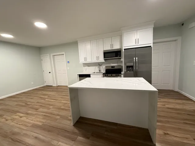 a room with wooden cabinets and refrigerator