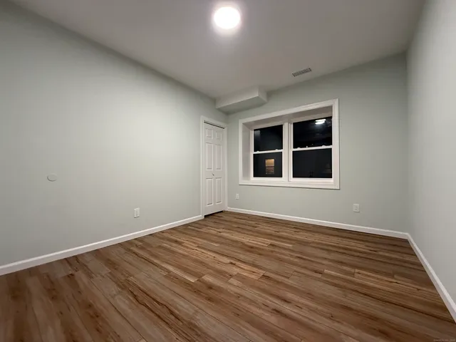 a view of empty room with wooden floor and windows