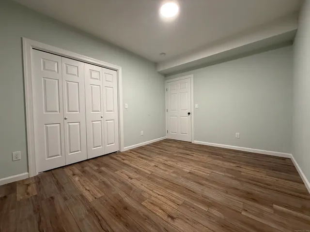 a view of empty room with wooden floor and windows