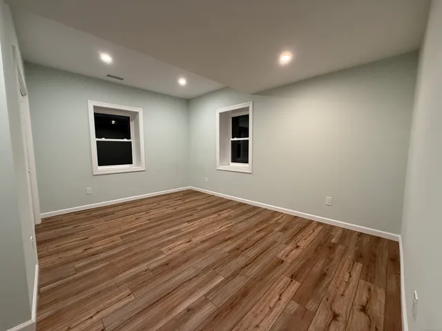 a view of empty room with wooden floor