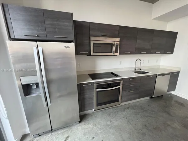 a kitchen with stainless steel appliances a refrigerator sink and microwave