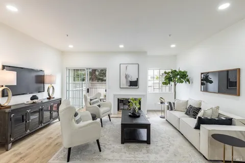 a living room with furniture a flat screen tv and a large window
