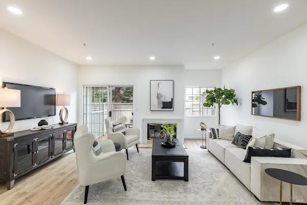 a living room with furniture a flat screen tv and a large window