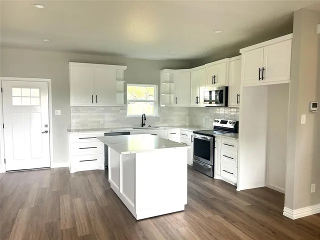 a kitchen with white cabinets and white appliances