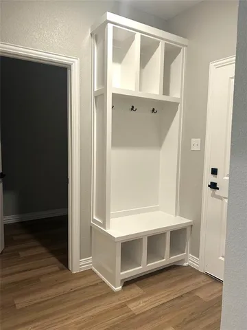 a view of an empty room with wooden floor and a cabinet