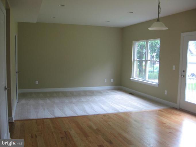 306 North Hammonds Ferry Road Linthicum Heights, MD 21090 - Photo 7 of 15 an empty room with wooden floor and windows