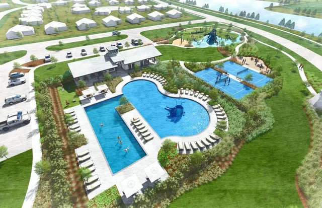 a blue swimming pool with a yard and plants