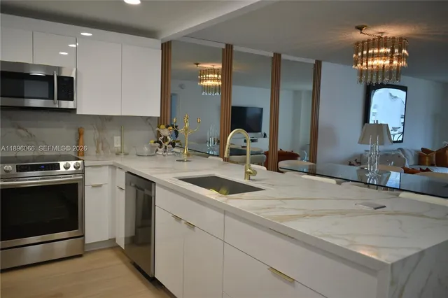 a kitchen with granite countertop a sink stainless steel appliances and cabinets