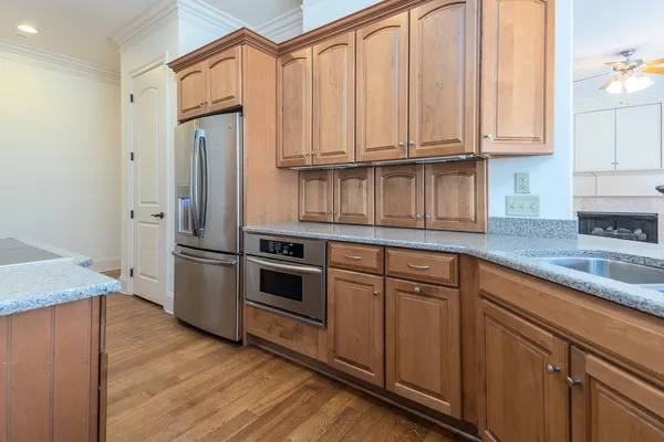 a view of kitchen with granite countertop cabinets and refrigerator