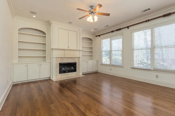 a view of an empty room with a window and fireplace