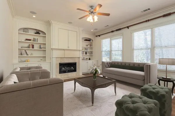 a living room with furniture a fireplace and a large window