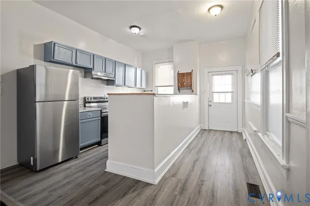 a kitchen with a refrigerator a microwave and cabinets