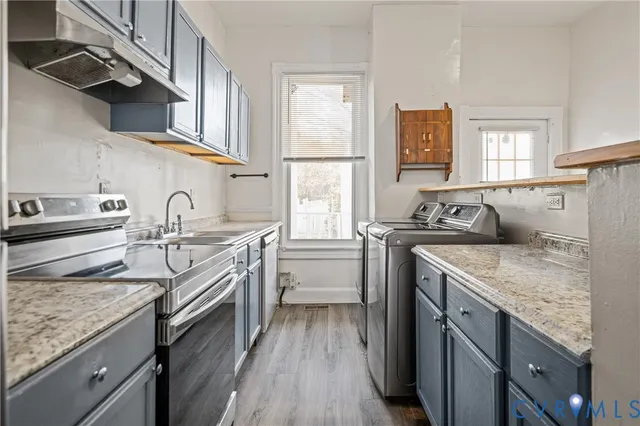 a kitchen with stainless steel appliances granite countertop a sink stove and cabinets