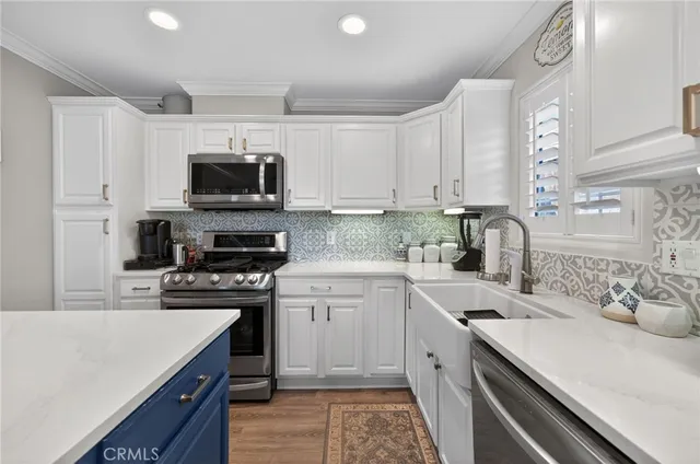 a kitchen with a refrigerator a stove a sink and chairs