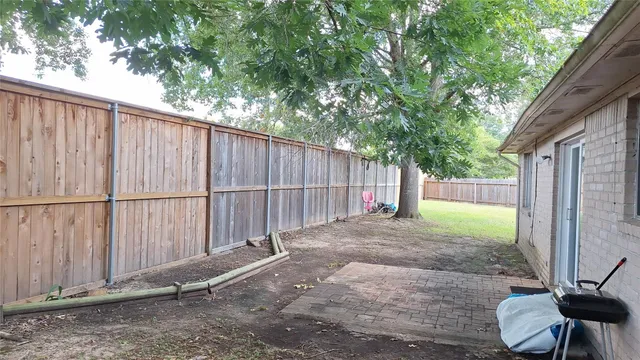 a view of backyard with wooden fence