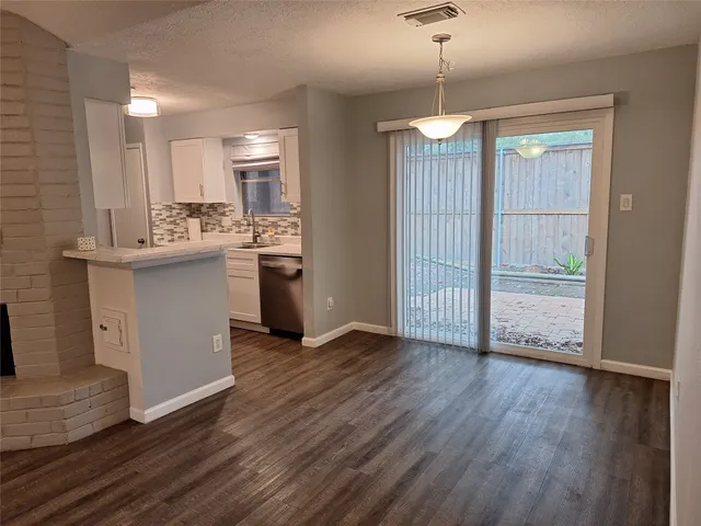 a view of kitchen with granite countertop stainless steel appliances and wooden floor