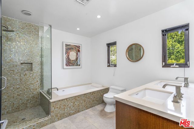 a bathroom with a granite countertop toilet sink and mirror