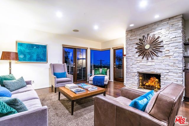 a living room with furniture a fireplace and a large window