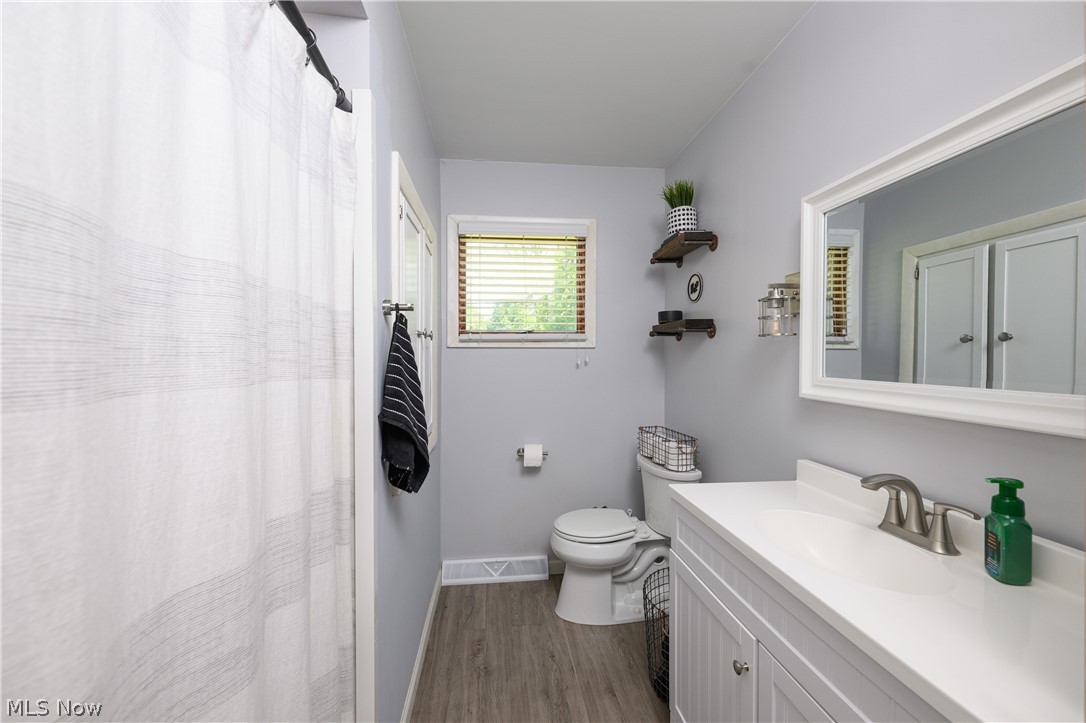 1243 Garman Road Akron, OH 44313 - Photo 16 of 21 Bathroom with toilet, oversized vanity, and hardwood / wood-style floors