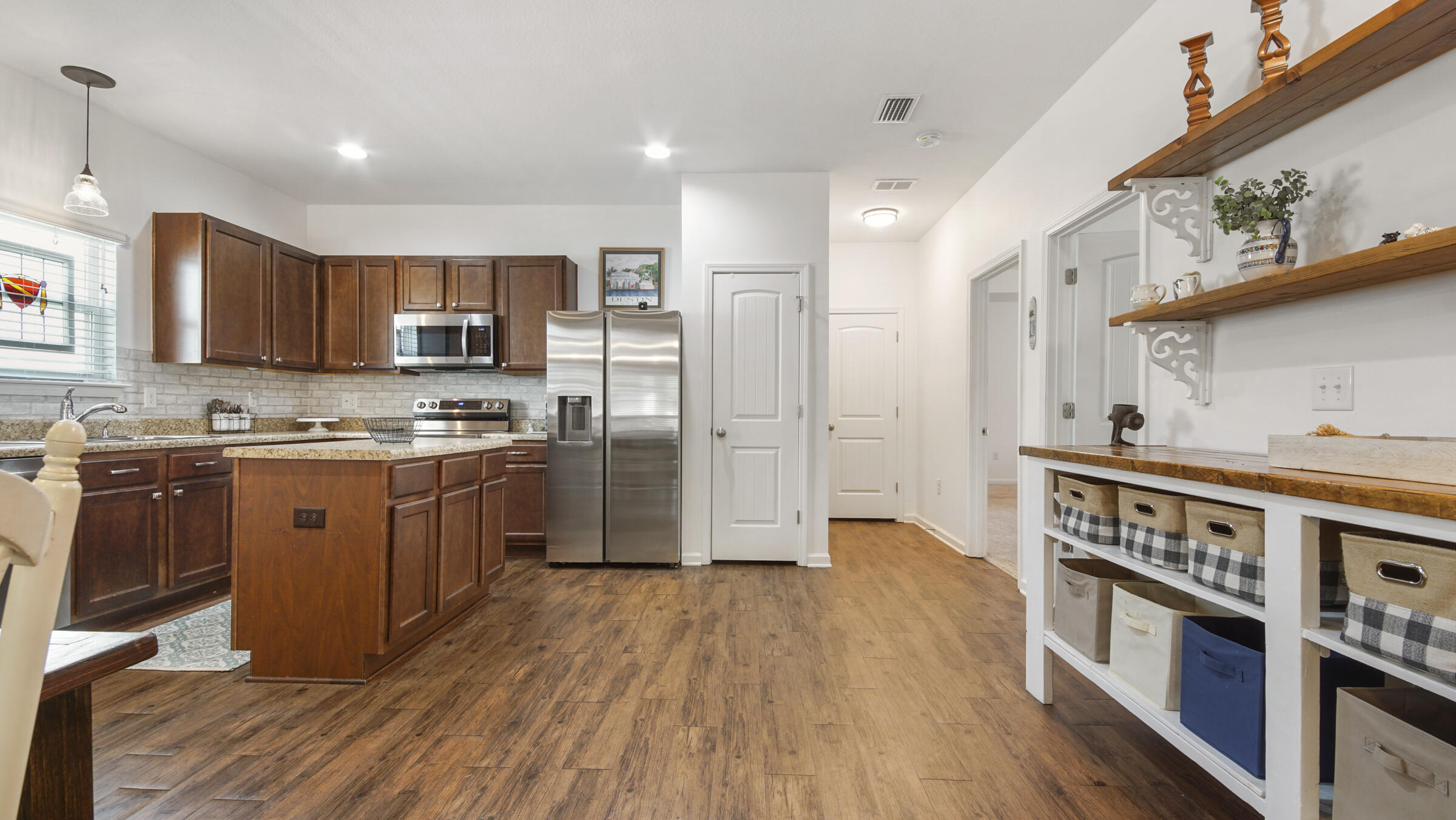 237 Nelly Street Freeport, FL 32439 - Photo 8 of 42 a kitchen with stainless steel appliances granite countertop a refrigerator a stove top oven a sink and dishwasher with wooden floor
