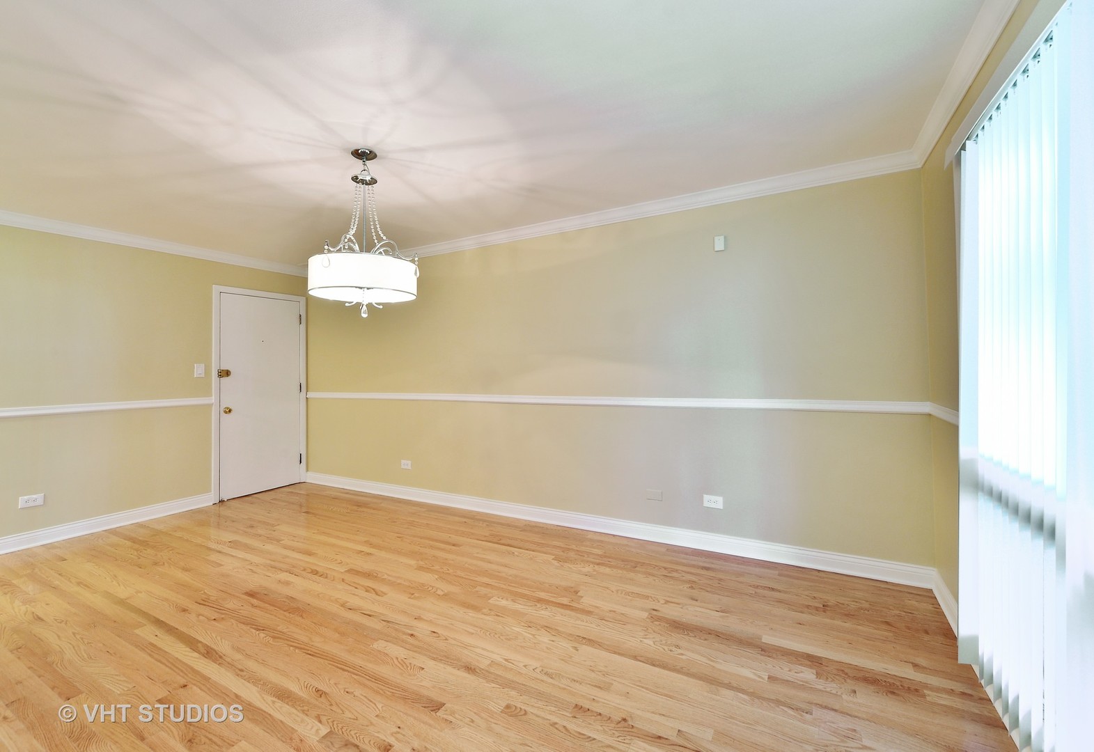 1247 South Mannheim Road, Unit 3 Westchester, IL 60154 - Photo 5 of 12 an empty room with wooden floor and chandelier