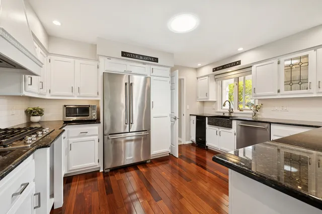 a kitchen with granite countertop white cabinets and white appliances