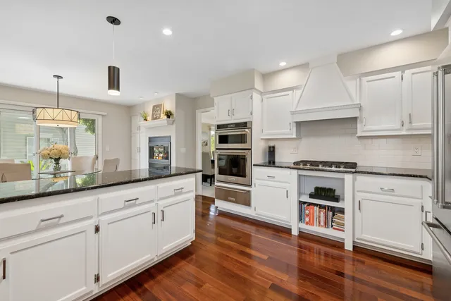 a kitchen with granite countertop white cabinets and a sink