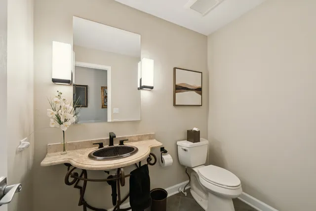 a bathroom with a toilet a sink and a mirror