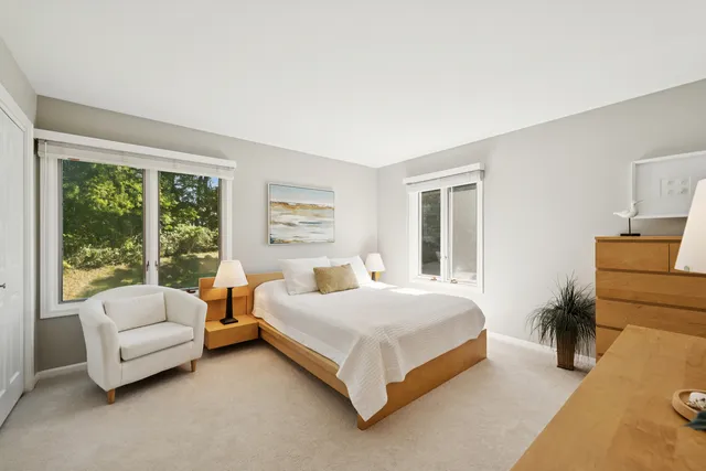 a bedroom with furniture and large windows