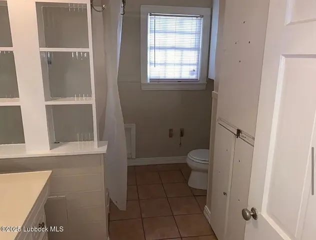 a bathroom with a granite countertop toilet and a shower