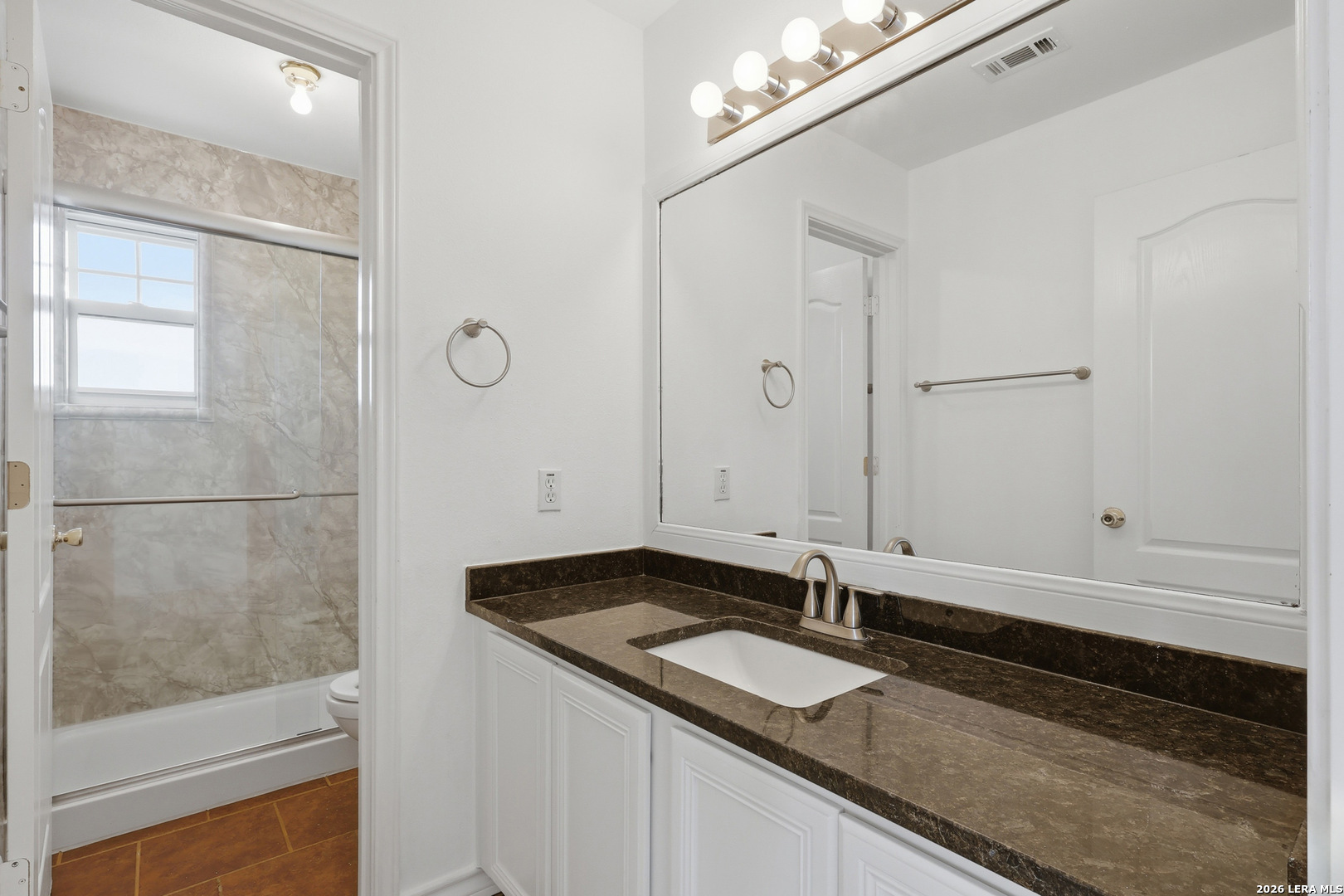 9348 Remuda Path San Antonio, TX 78254 - Photo 20 of 27 a bathroom with a granite countertop sink and a mirror
