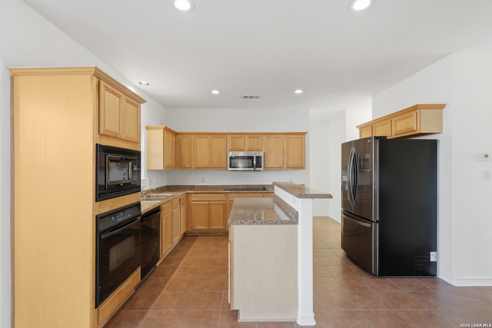 9348 Remuda Path San Antonio, TX 78254 - Photo 8 of 27 a kitchen with granite countertop a refrigerator stove and oven