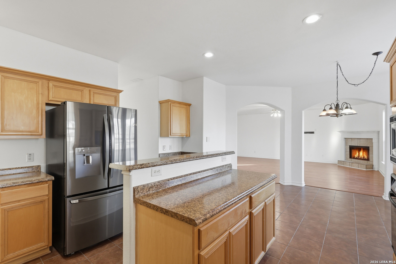 9348 Remuda Path San Antonio, TX 78254 - Photo 10 of 27 a kitchen with stainless steel appliances granite countertop a refrigerator a stove and a sink with wooden floors