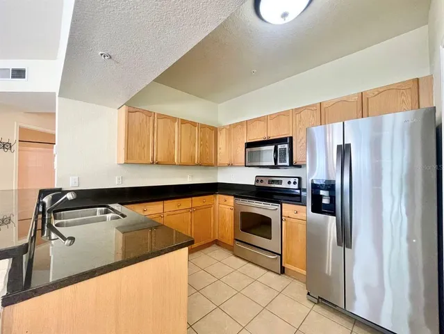 a kitchen with stainless steel appliances a refrigerator sink and microwave