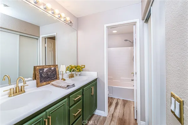 a bathroom with a granite countertop sink a mirror and a bathtub