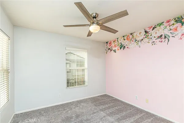 an empty room with window and ceiling fan