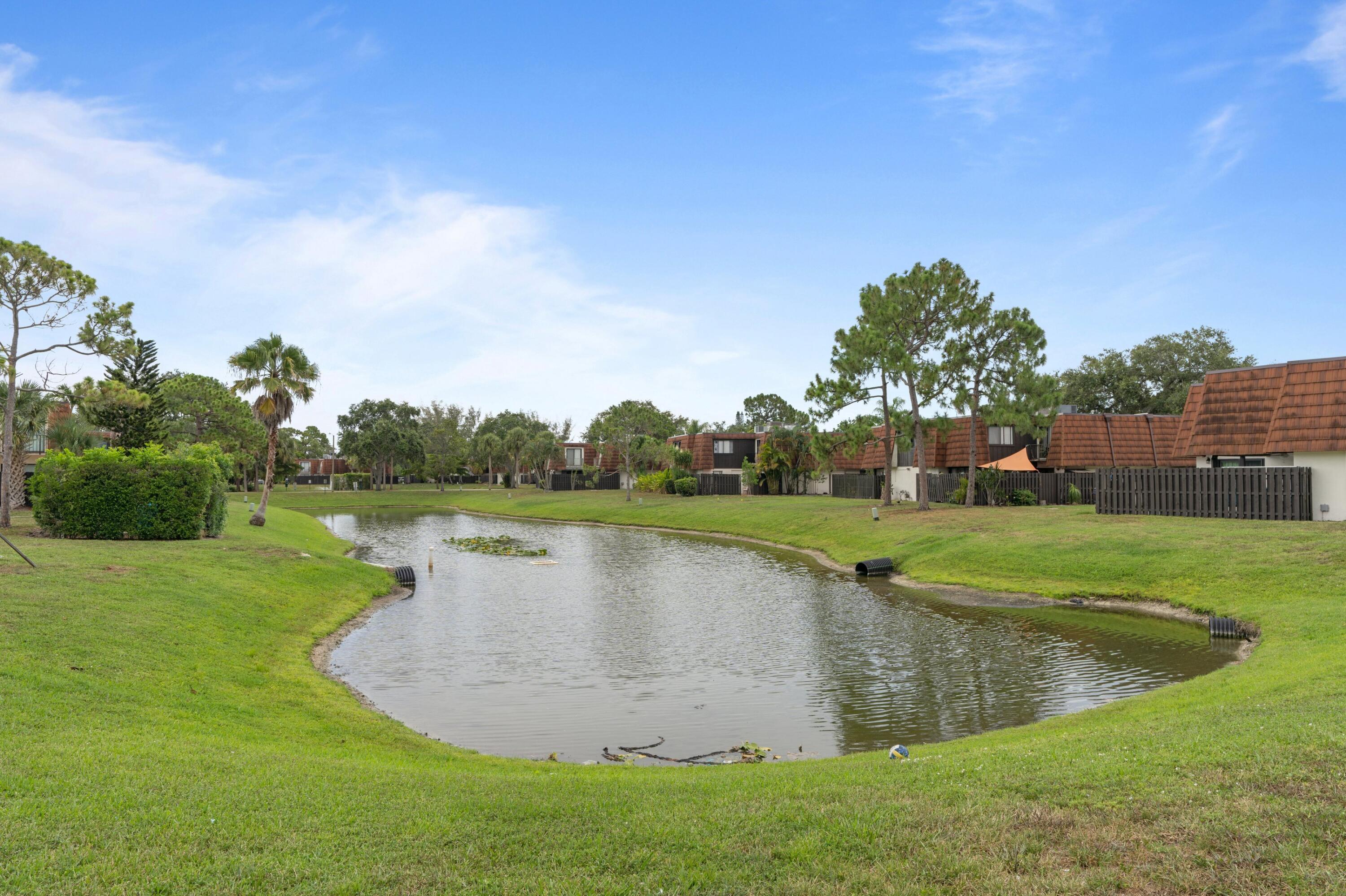 2247 White Pine Circle, Unit A Greenacres, FL 33415 - Photo 20 of 27 a view of a lake with a big yard