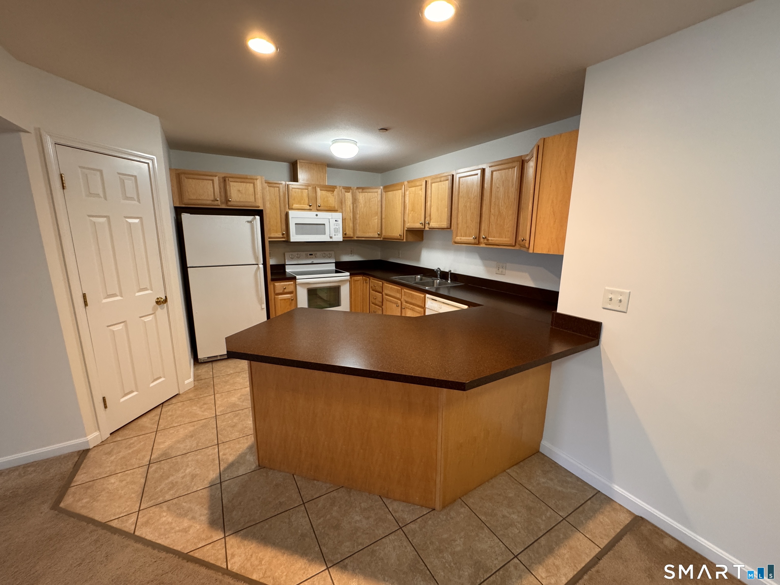 128 Meridian Street, Unit 211 Groton, CT 06340 - Photo 20 of 23 a kitchen with stainless steel appliances granite countertop a refrigerator sink and microwave
