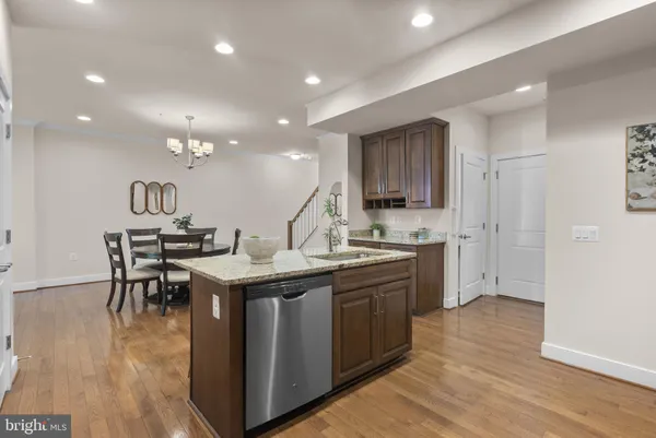 a kitchen with stainless steel appliances granite countertop a sink stove and wooden floor