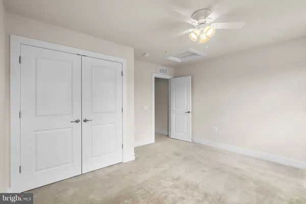 an empty room with a ceiling fan and a closet