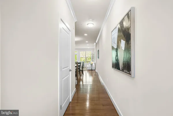 a view of a hallway with wooden floor and a potted plant