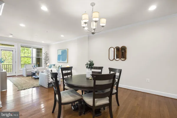 a view of a dining room with furniture a chandelier and wooden floor