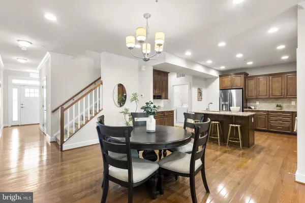 a view of a dining room with furniture a chandelier and wooden floor