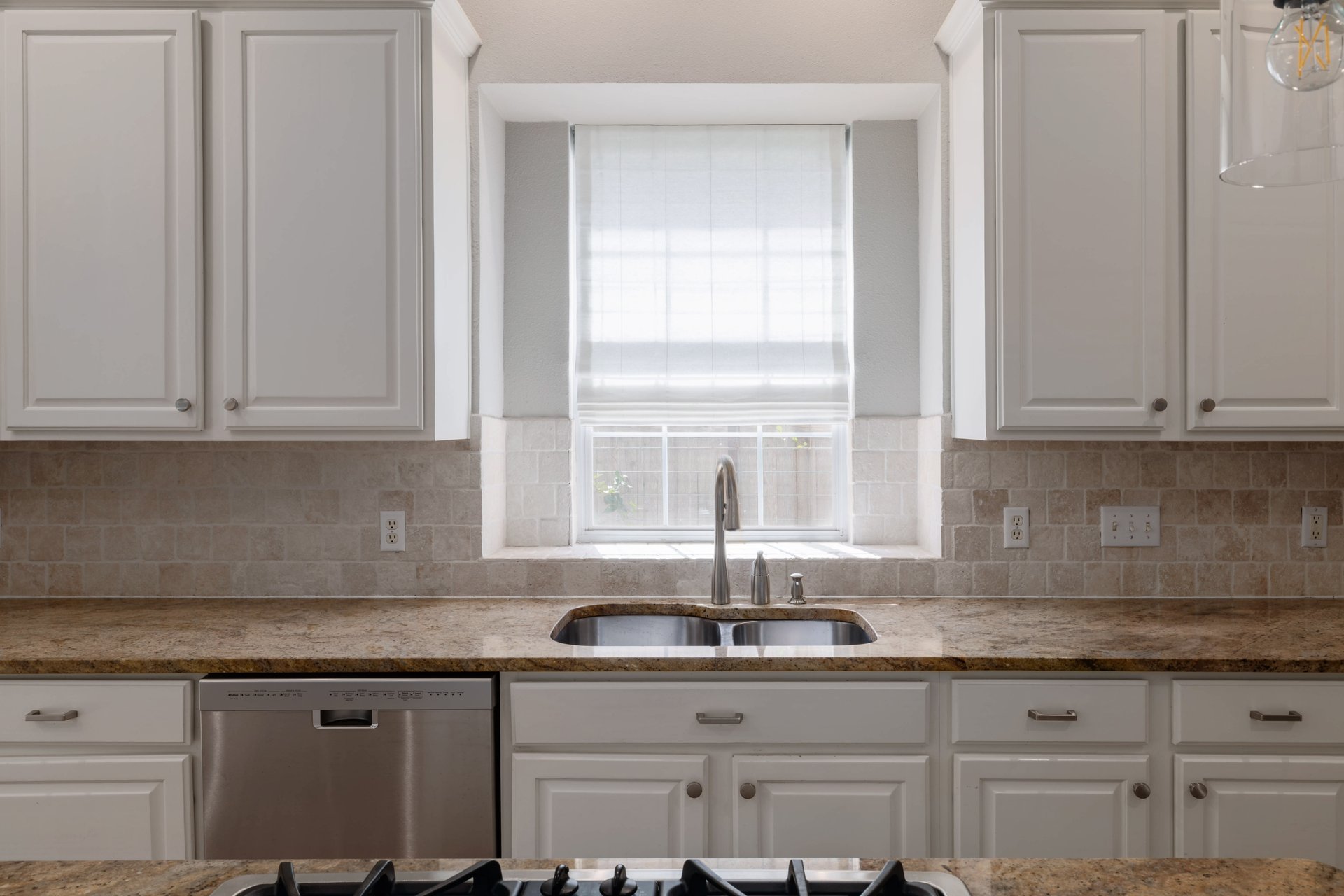 5512 Ballenton Lane Austin, TX 78739 - Photo 14 of 40 A well-appointed kitchen features ample cabinetry, a double basin sink, and a modern dishwasher.