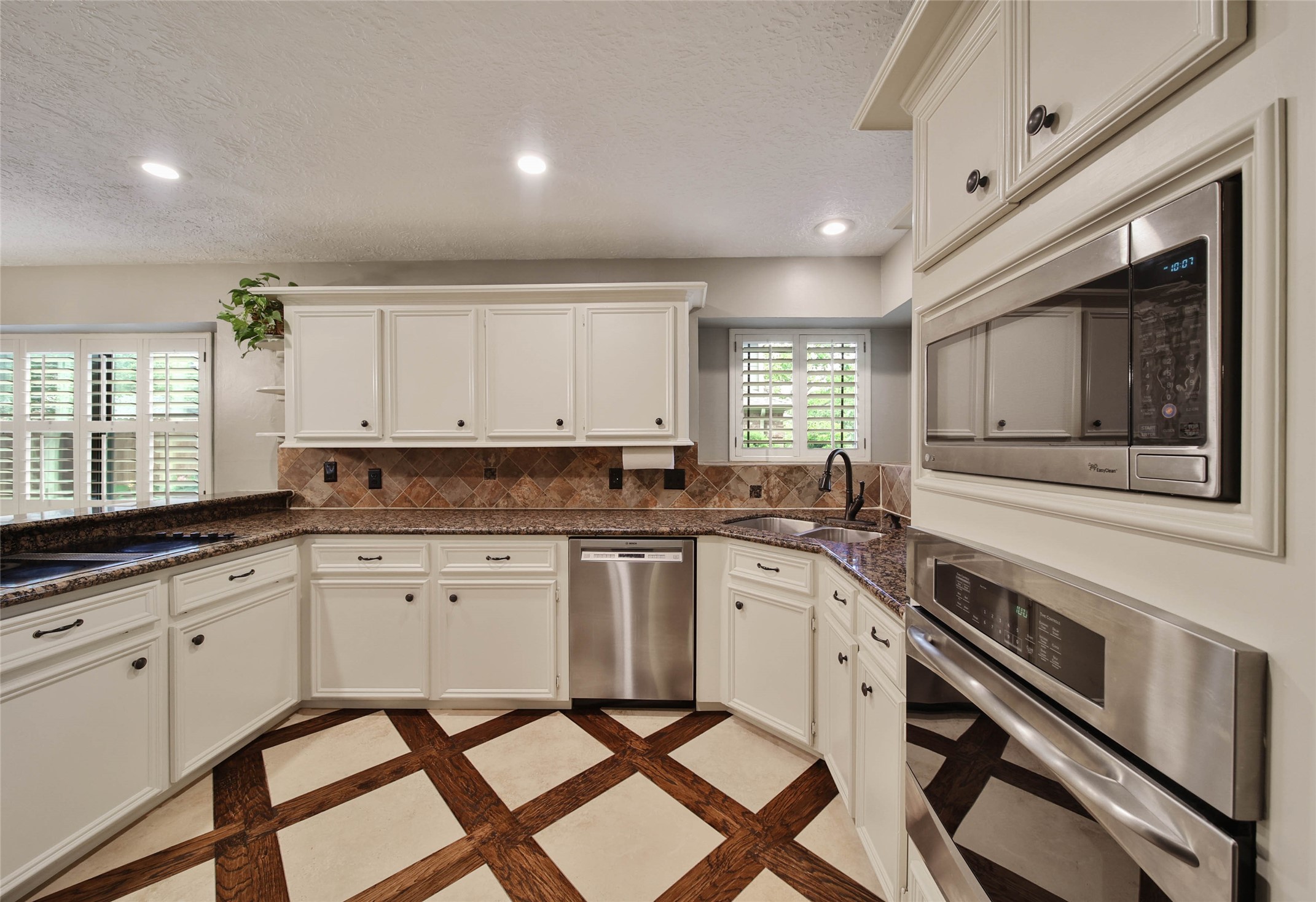 17007 Windrow Drive Spring, TX 77379 - Photo 16 of 46 a kitchen with granite countertop white cabinets white appliances a sink and a window