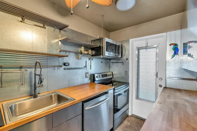 a kitchen that has a sink a stove and cabinets