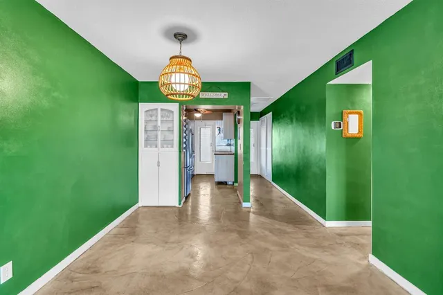 a view of a hallway with a yellow lightning and a yard