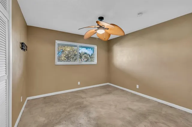 an empty room with a fan and a chandelier fan